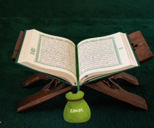Open Qur’an placed on wooden stand with a zakat money bag illustration, symbolizing charity and Islamic giving